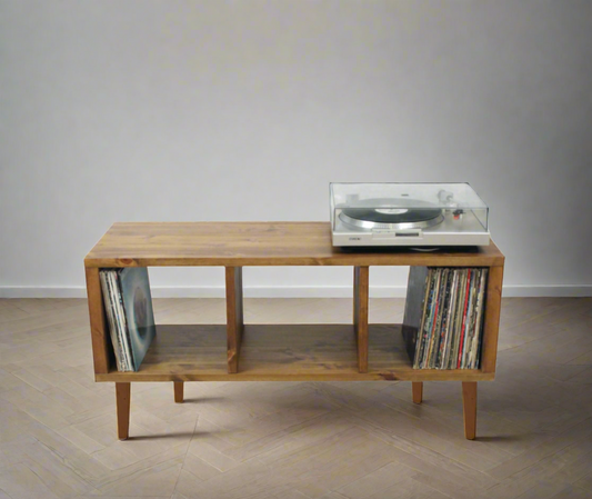 A wooden record player stand with storage for vinyl LPs and a turntable placed on top.