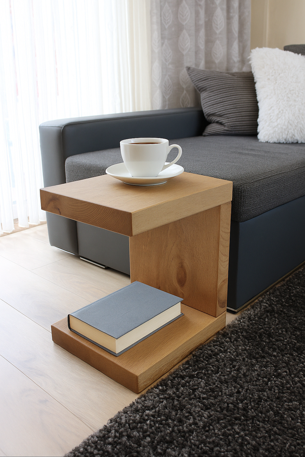 Wooden side table with a book and coffee cup on a gray sofa