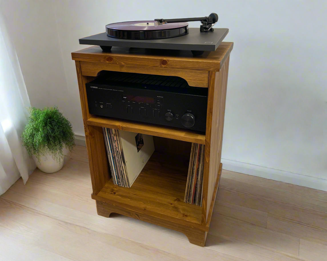 Wooden record player cabinet with turntable and stereo equipment on a light wooden floor.
