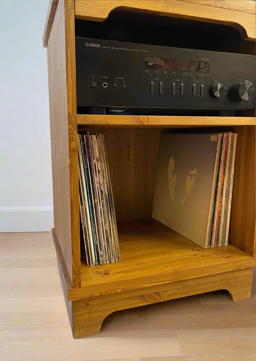 Wooden record player cabinet with vinyl records and a Yamaha amplifier.